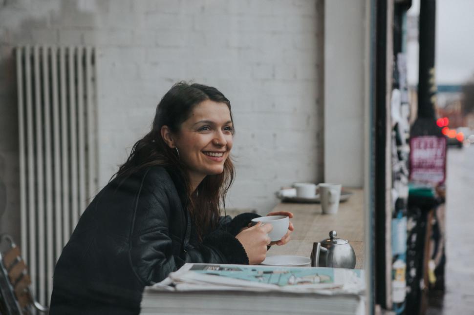 Free Image of Woman Sitting at Table With Cup of Coffee 