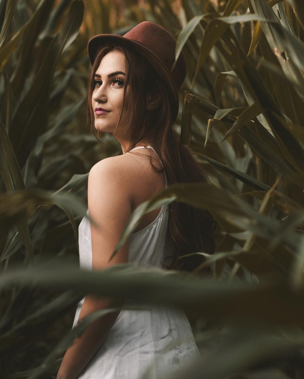 Free Image of Woman Wearing a Hat Standing in a Field 