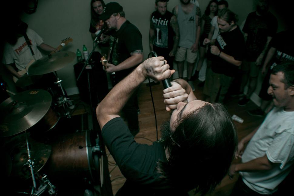 Free Image of Man Holding Microphone in Front of Group of People 