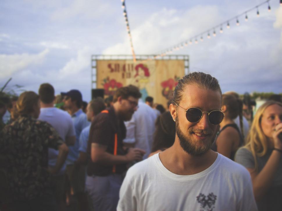 Free Image of Man Wearing Sunglasses Standing in Front of Crowd 
