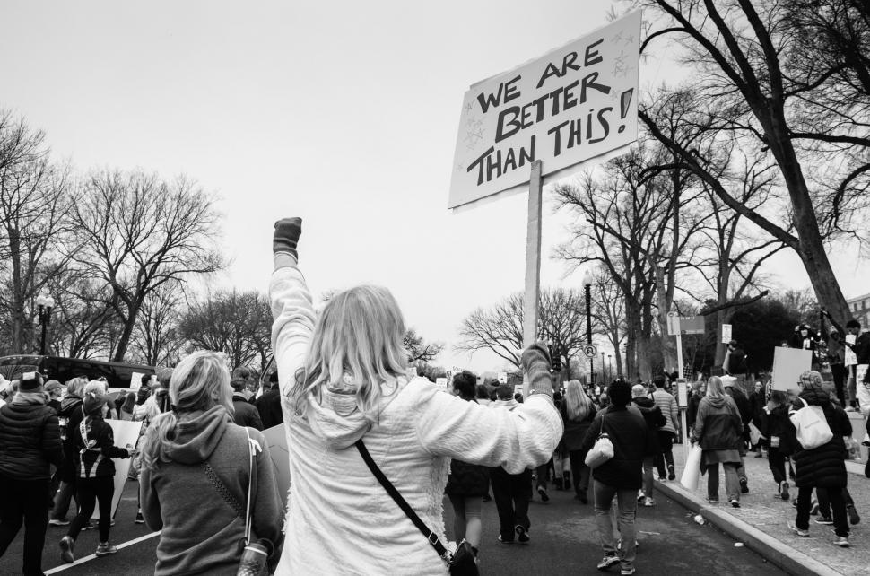 Free Image of Group of People Walking Down a Street Holding Signs 