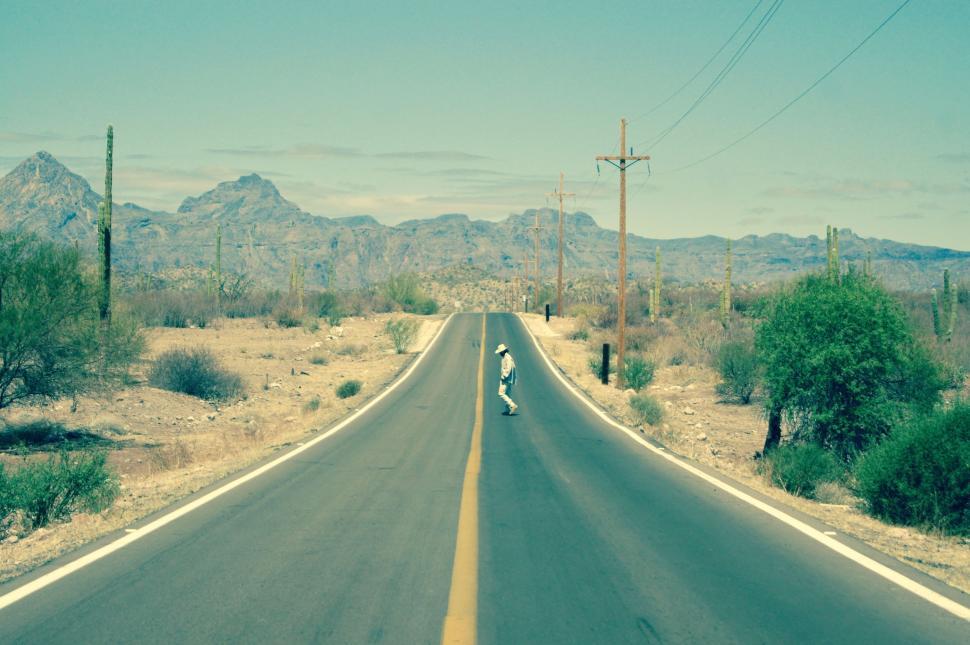 Free Image of Person Riding Motorcycle Down Desert Road 