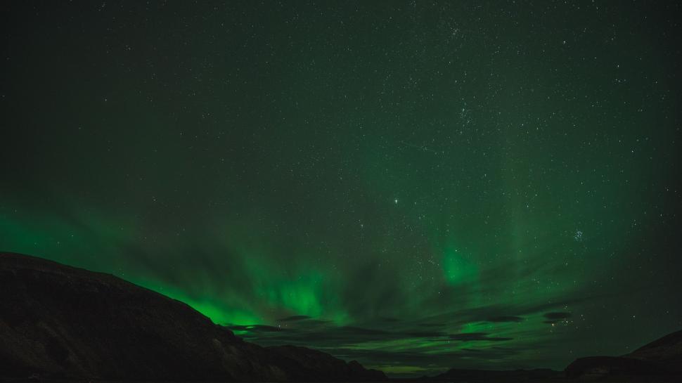 Free Image of Green and Black Sky With Clouds and Mountains 