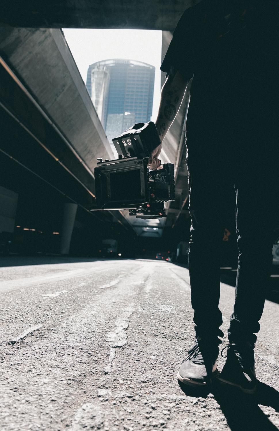 Free Image of Person Walking Down Street With Skateboard 