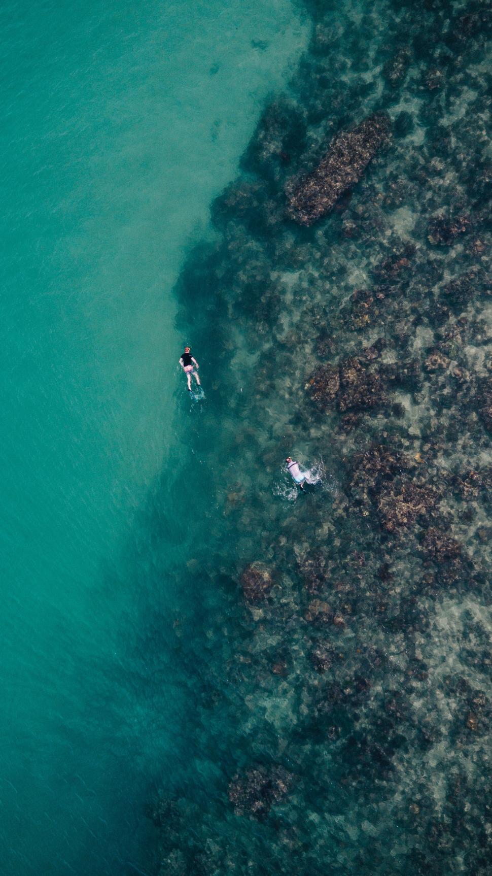 Free Image of Couple Riding on Top of a Surfboard 