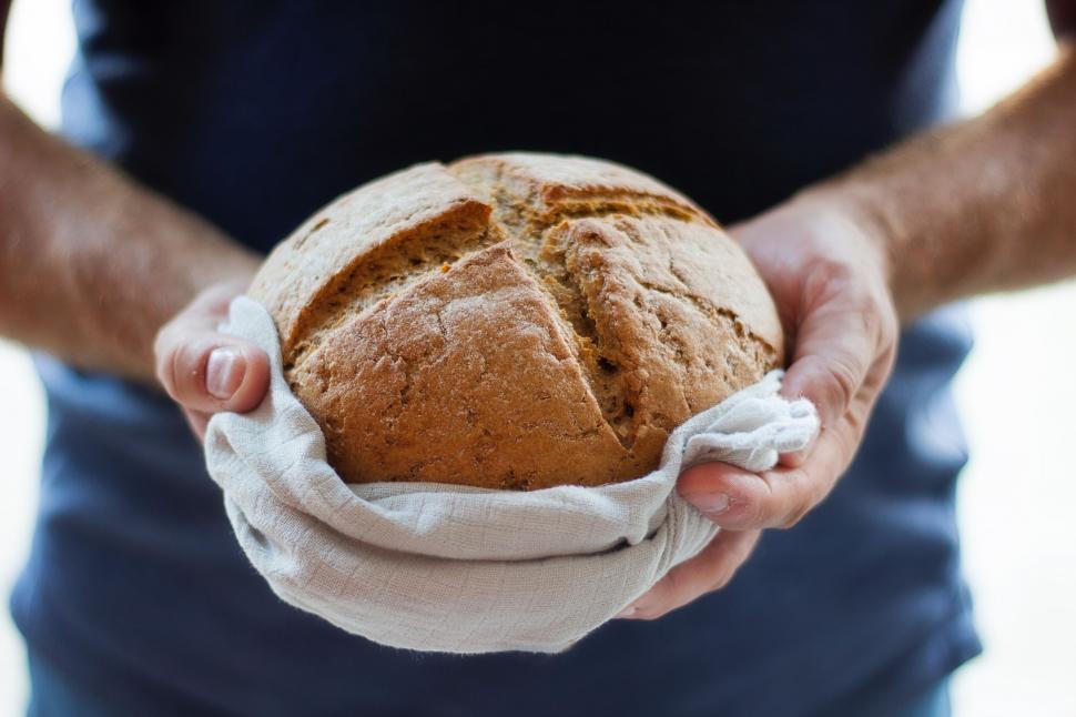 Free Image of Person Holding a Loaf of Bread 