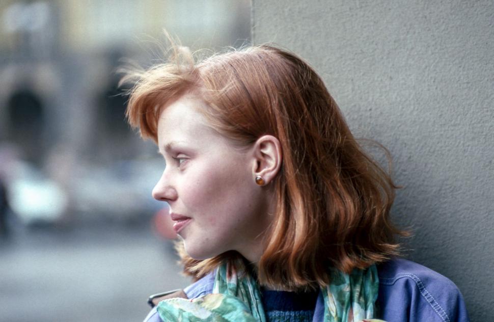 Free Image of Woman With Red Hair Standing Next to Wall 