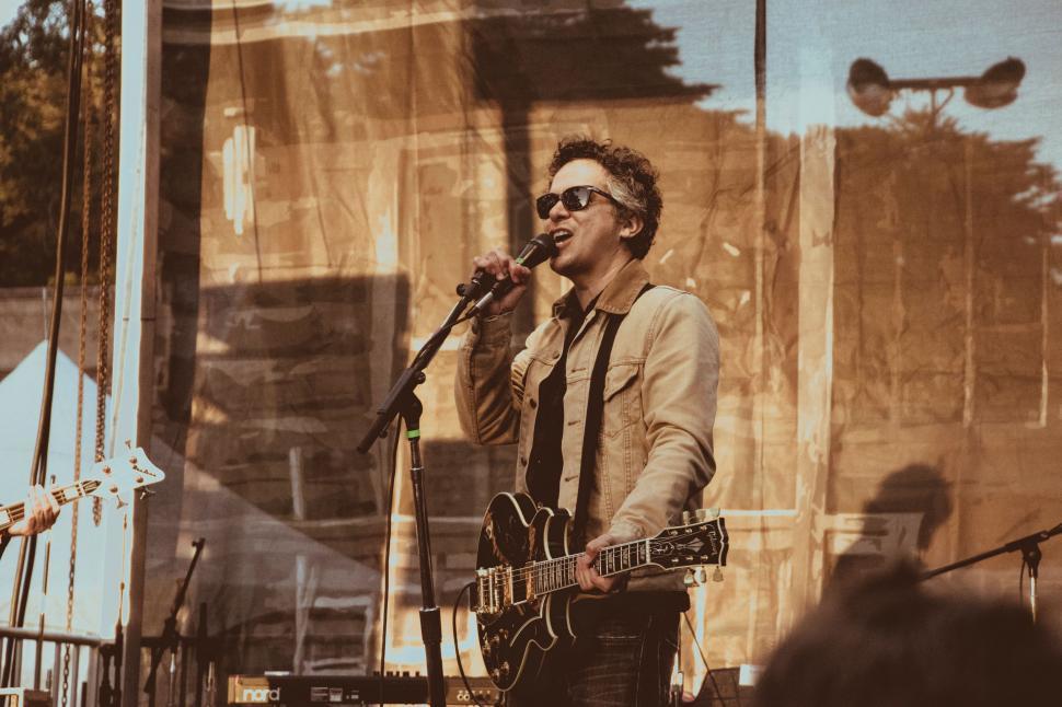 Free Image of Man Playing Guitar and Singing Into Microphone 