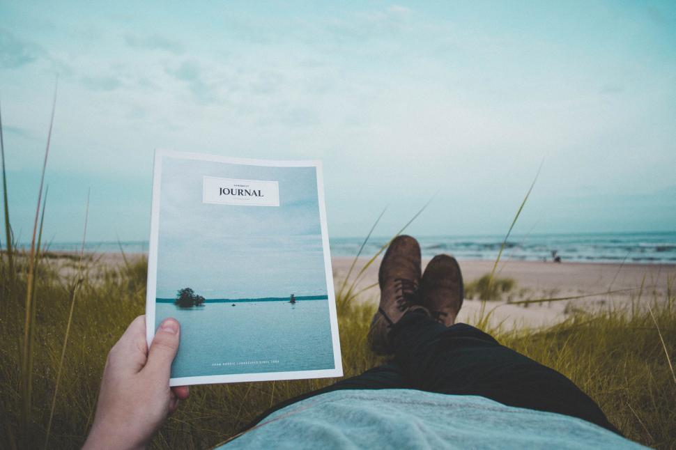 Free Image of Person Laying on Ground With Book 