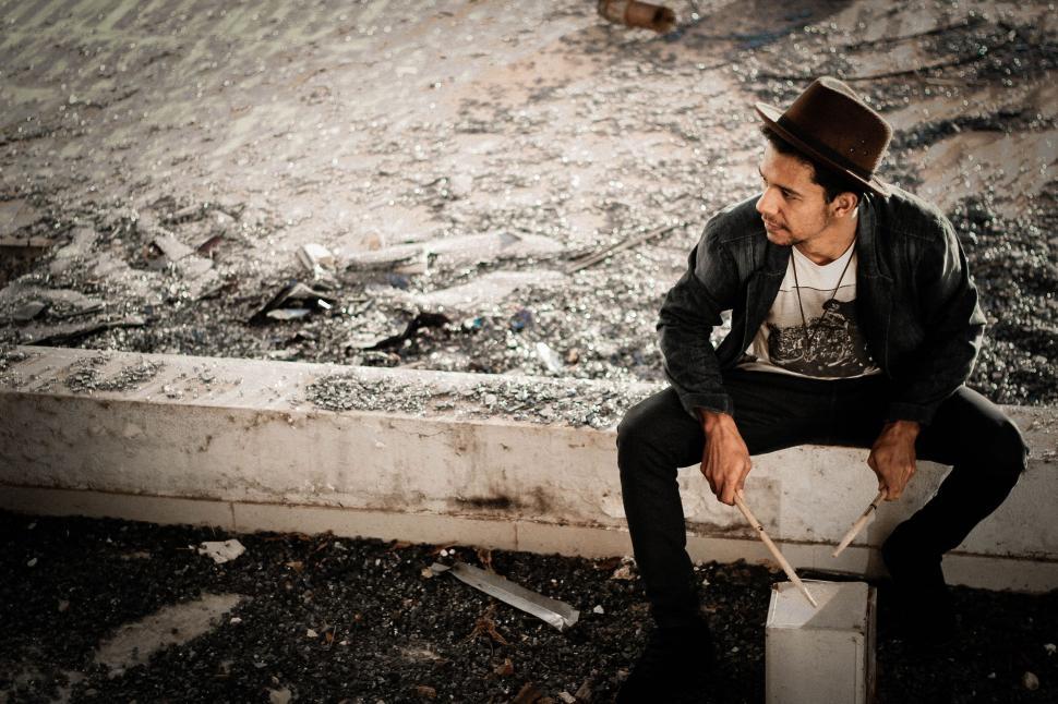 Free Image of Man Sitting on Top of a White Box 