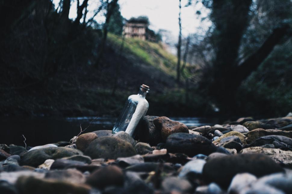 Free Image of Bottle Resting on Pile of Rocks 