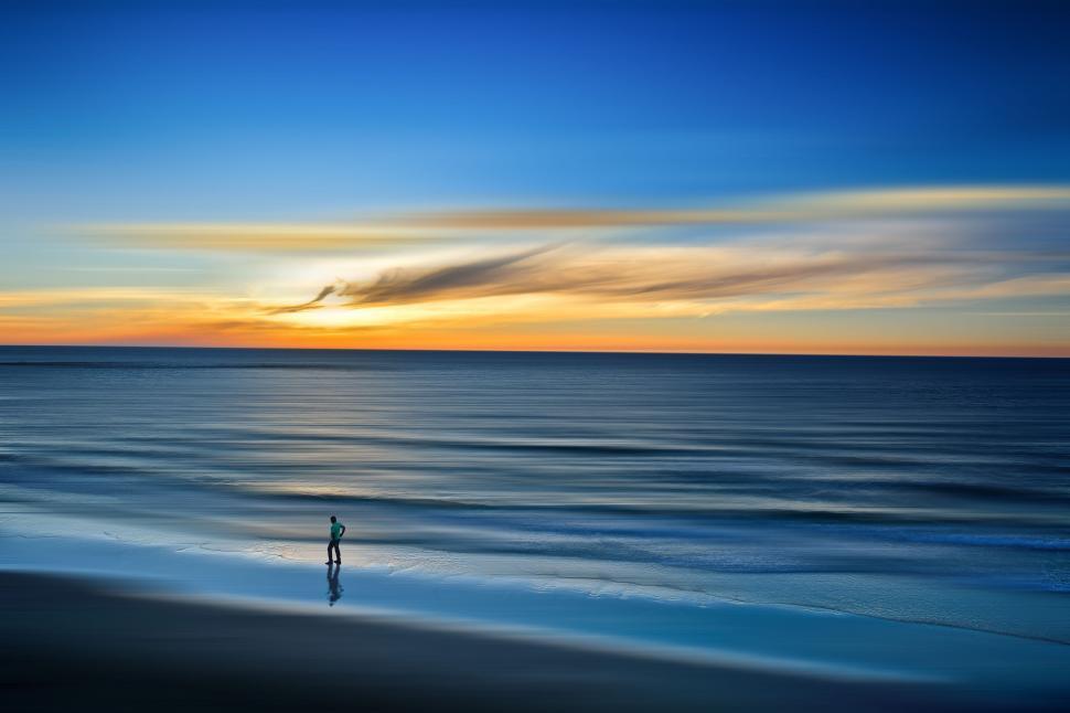 Free Image of Person Standing on Beach at Sunset 
