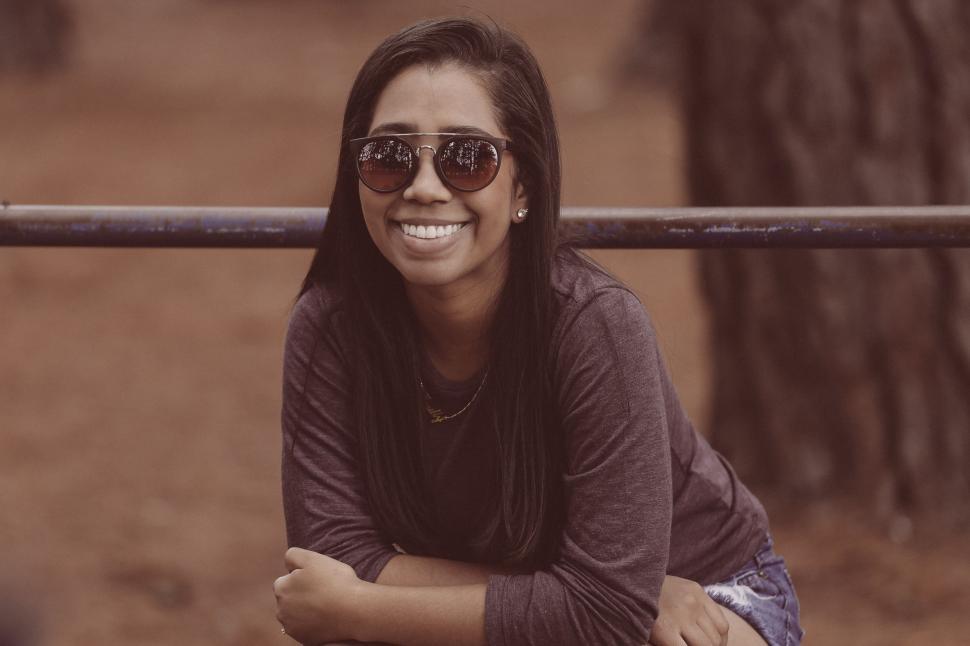 Free Image of Woman Wearing Sunglasses Sitting on a Bench 