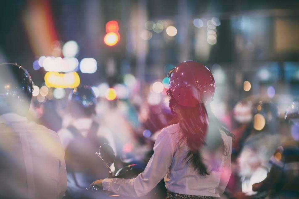 Free Image of Woman Riding Motorcycle Down Street at Night 