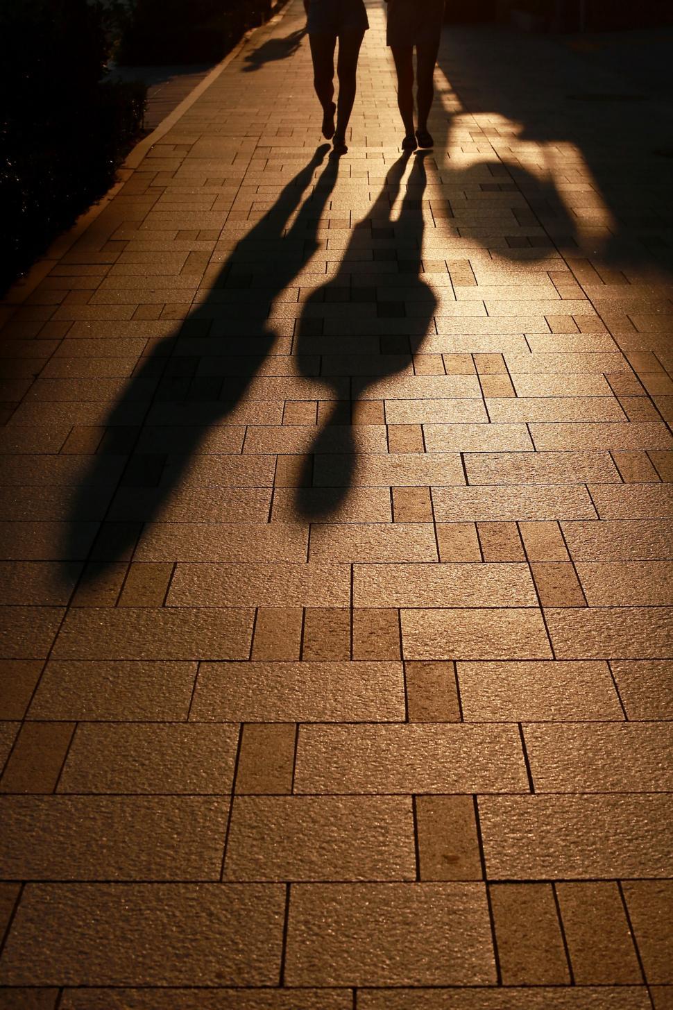 Free Image of Couple Walking Down Sidewalk 