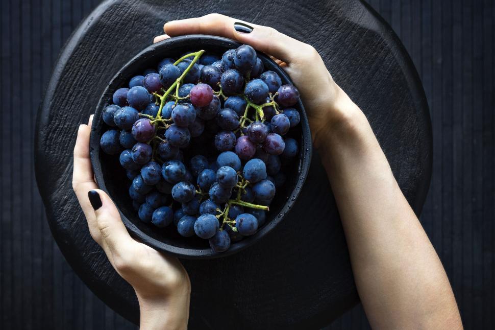 Free Image of Two Hands Holding a Bowl of Grapes 