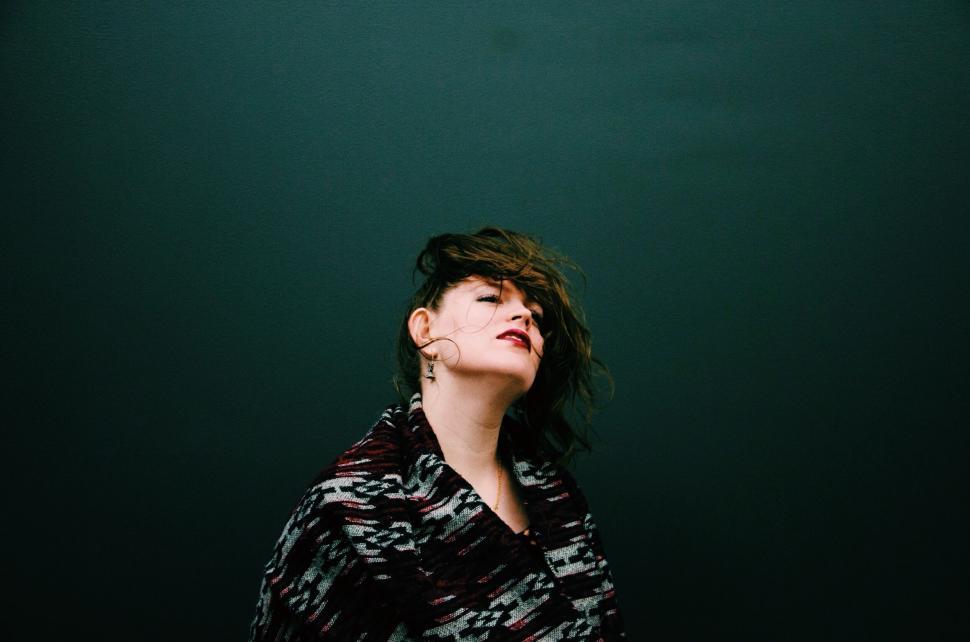 Free Image of Woman Standing in Front of Green Wall 