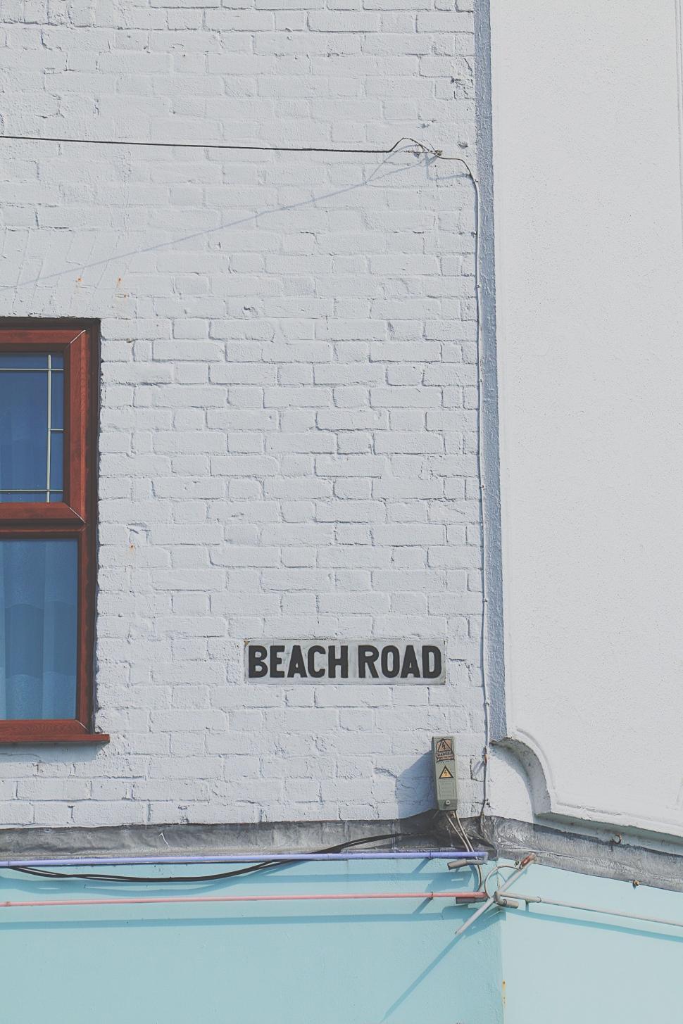 Free Image of White Brick Building With Red Window 