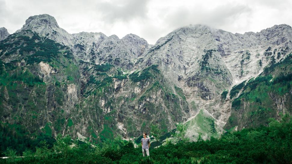 Free Image of Man Standing on Top of Lush Green Hillside 