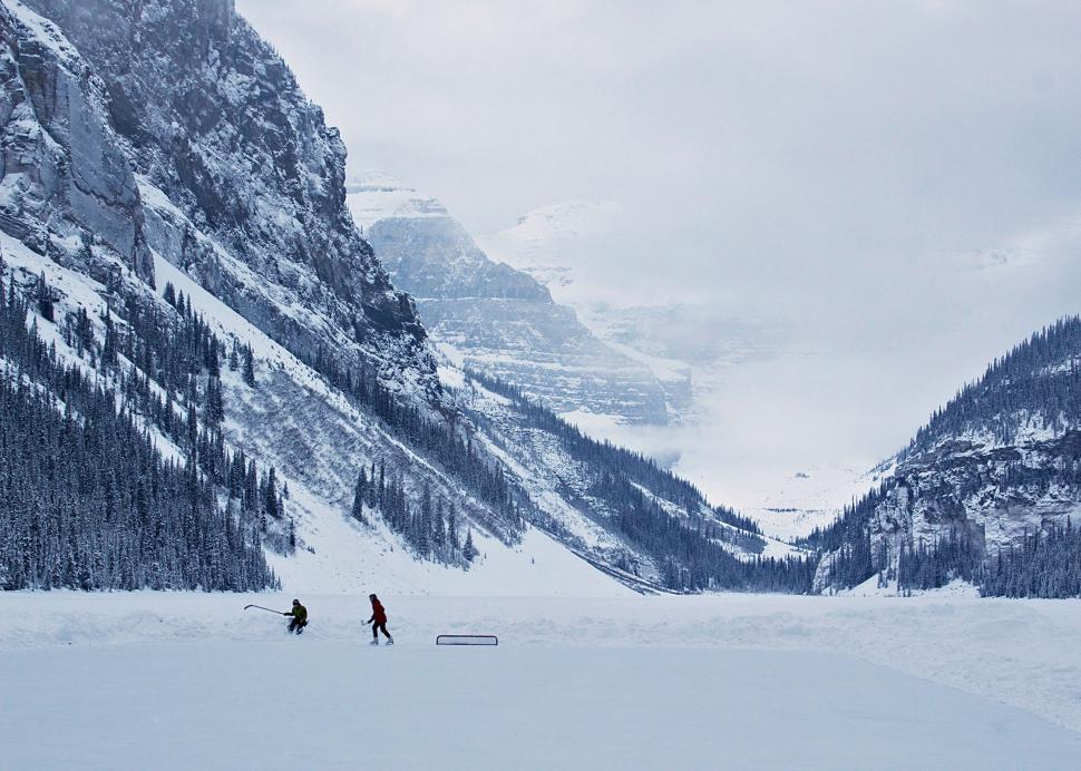 Free Image of Couple Skiing Across Snowy Slope 