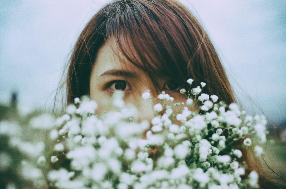 Free Image of Woman Holding Bunch of White Flowers 