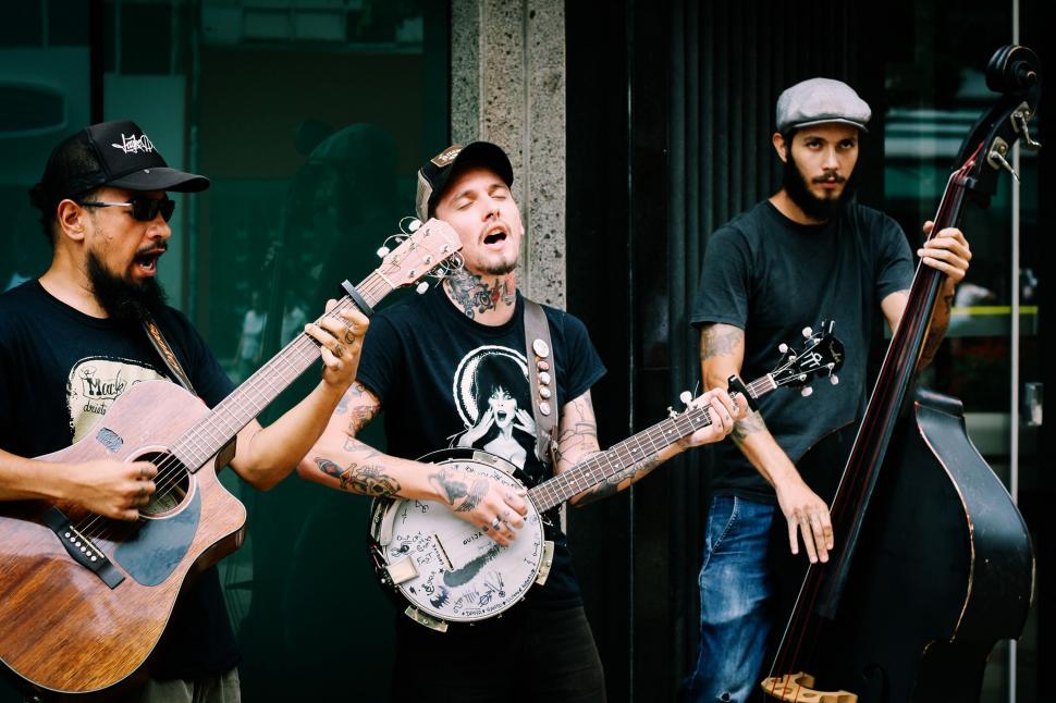 Free Image of Group of Men Standing Holding Guitars 