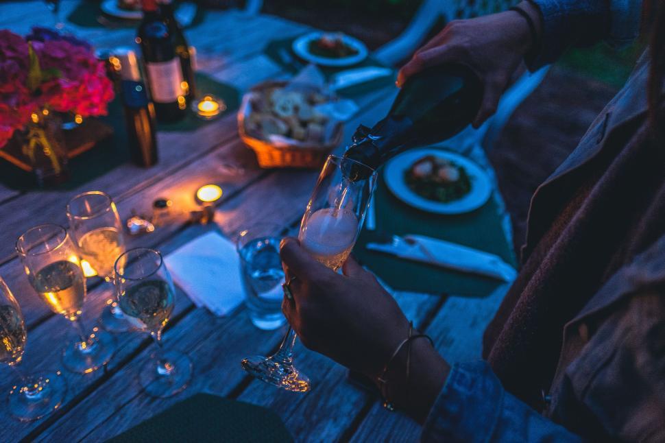 Free Image of Person Pouring Glass of Wine at Dinner Table 