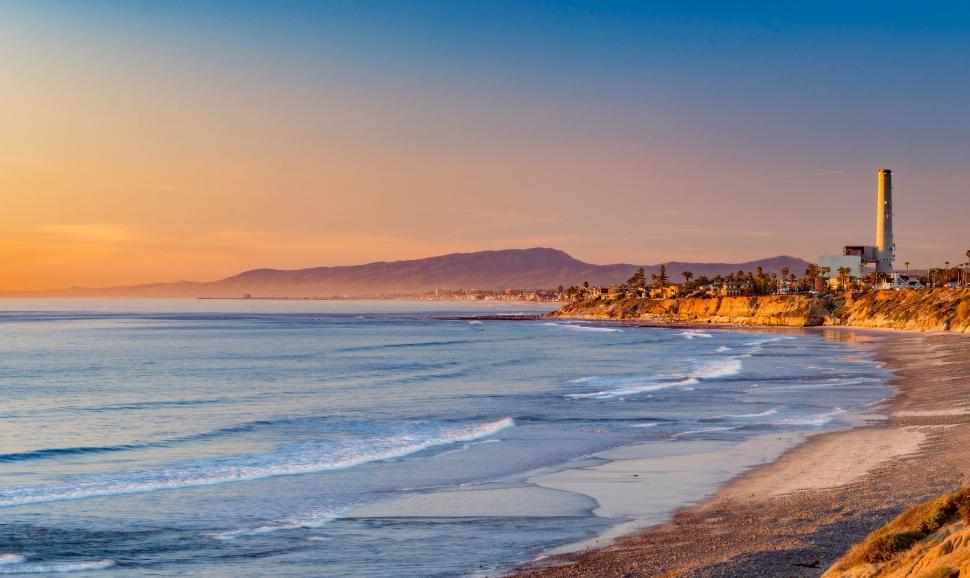 Free Image of A View of a Beach With a Lighthouse in the Distance 