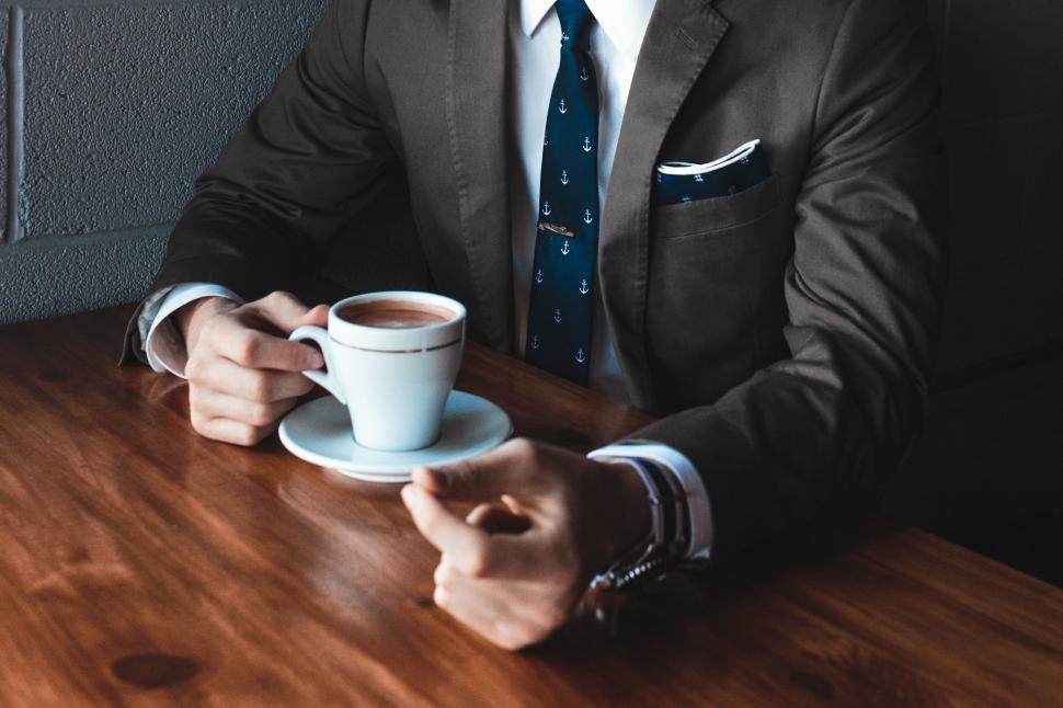 Free Image of Man Sitting at Table With Cup of Coffee 
