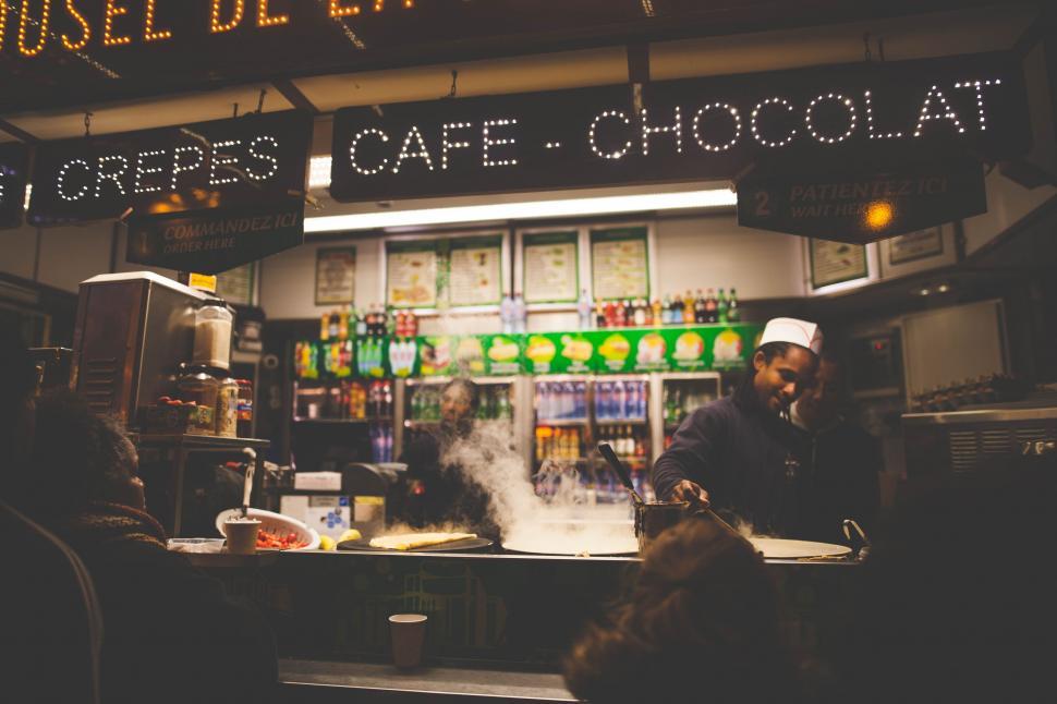 Free Image of Man Standing in Front of Food-Filled Counter 