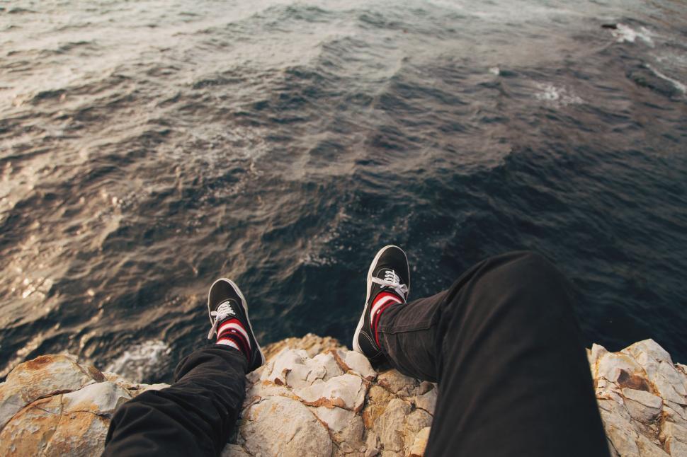 Free Image of Person Sitting on Rock by Ocean 