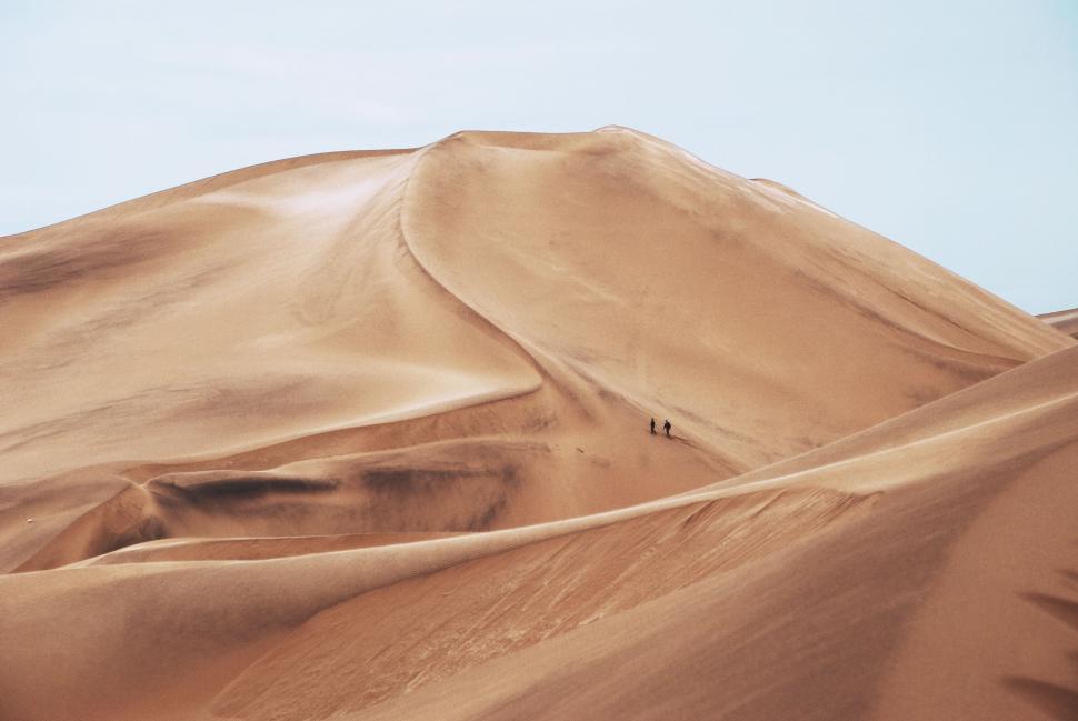 Free Image of Group of People Standing on Top of a Sand Dune 