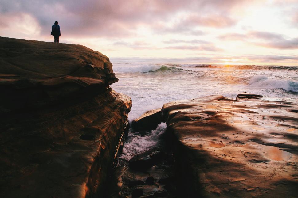 Free Image of Person Standing on Cliff by Ocean 