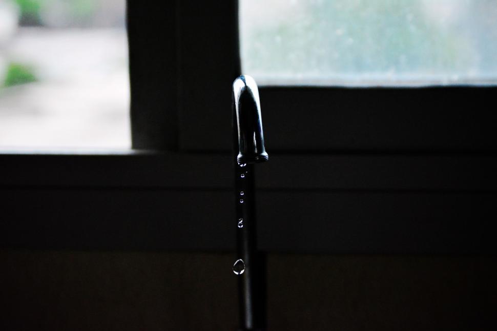 Free Image of Close Up of Water Faucet With Window in Background 
