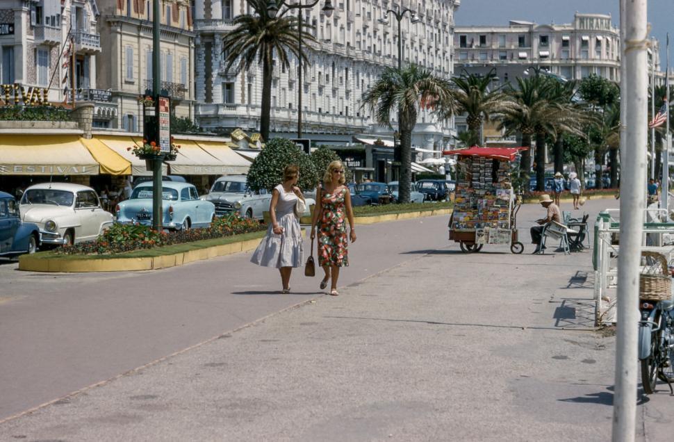 Free Image of Women Walking Down City Street Amid Tall Buildings 