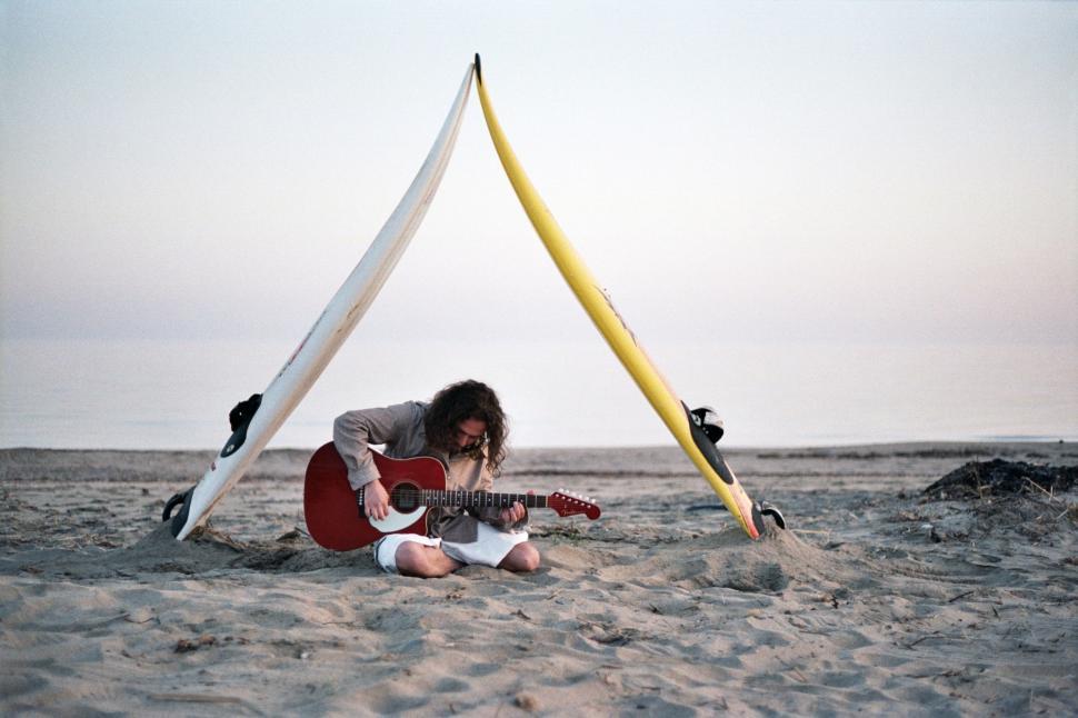 Free Image of Man Sitting in the Sand With Guitar 