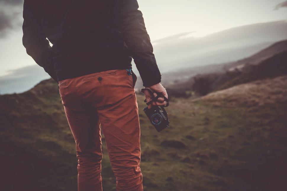 Free Image of Man Standing on Top of Lush Green Hillside 
