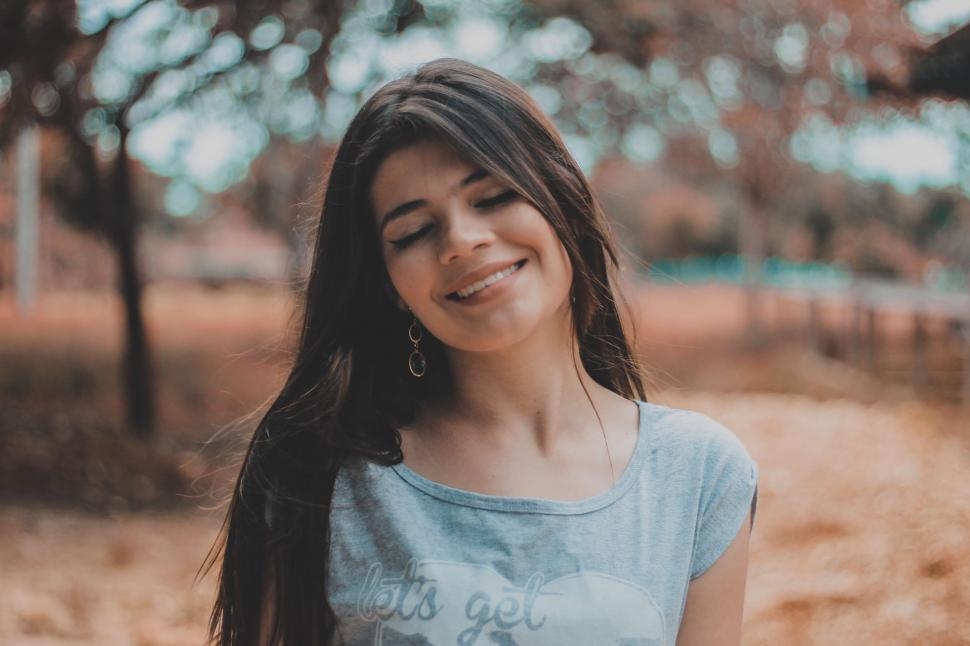 Free Image of Woman Standing in Field With Eyes Closed 