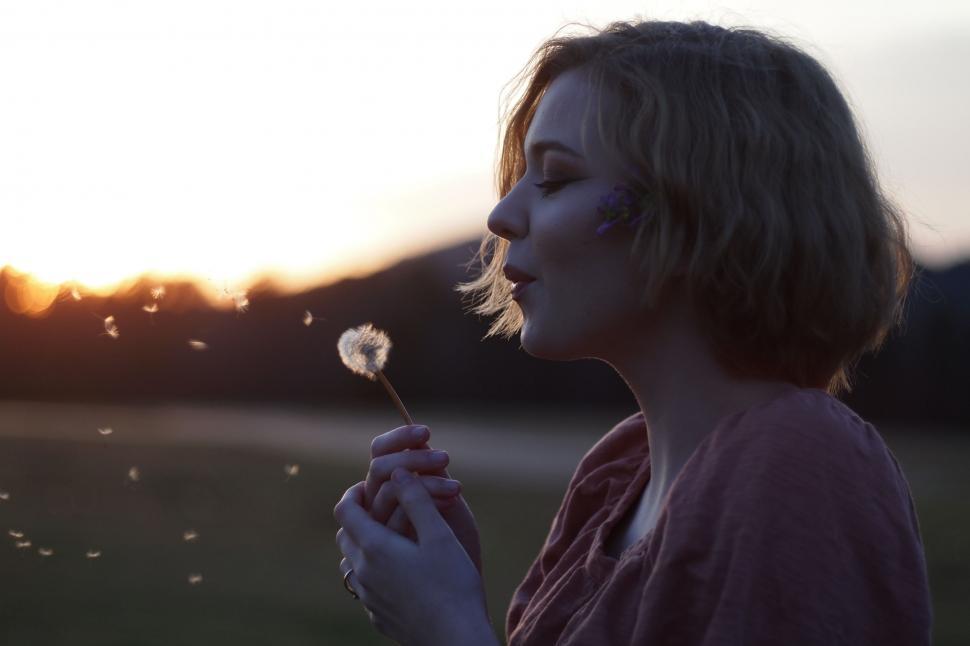Free Image of Woman Blowing Dandelion in Field 