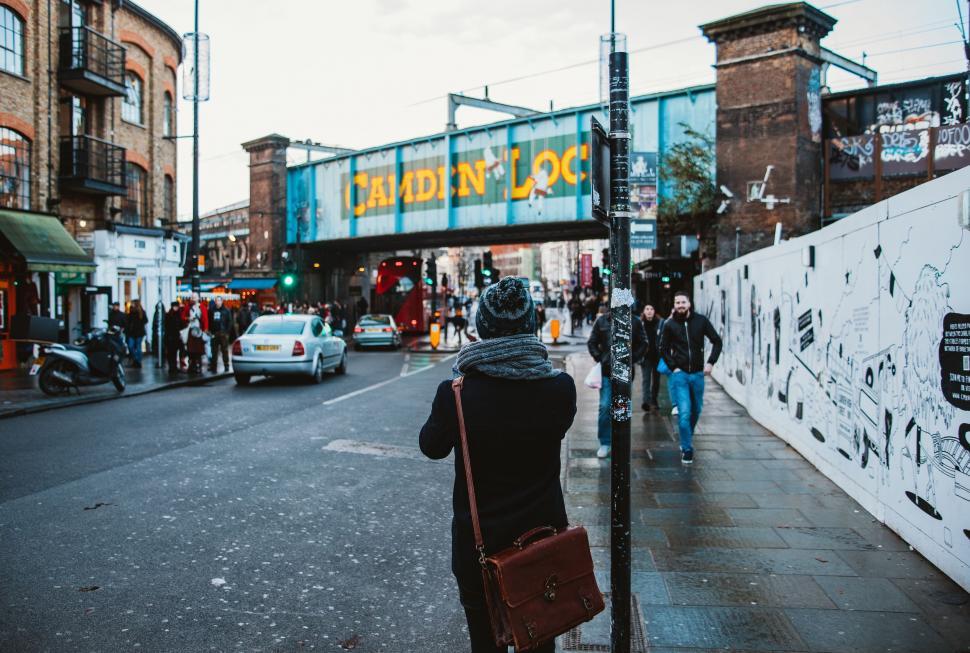 Free Image of Woman Walking Down a City Street Next to Tall Buildings 