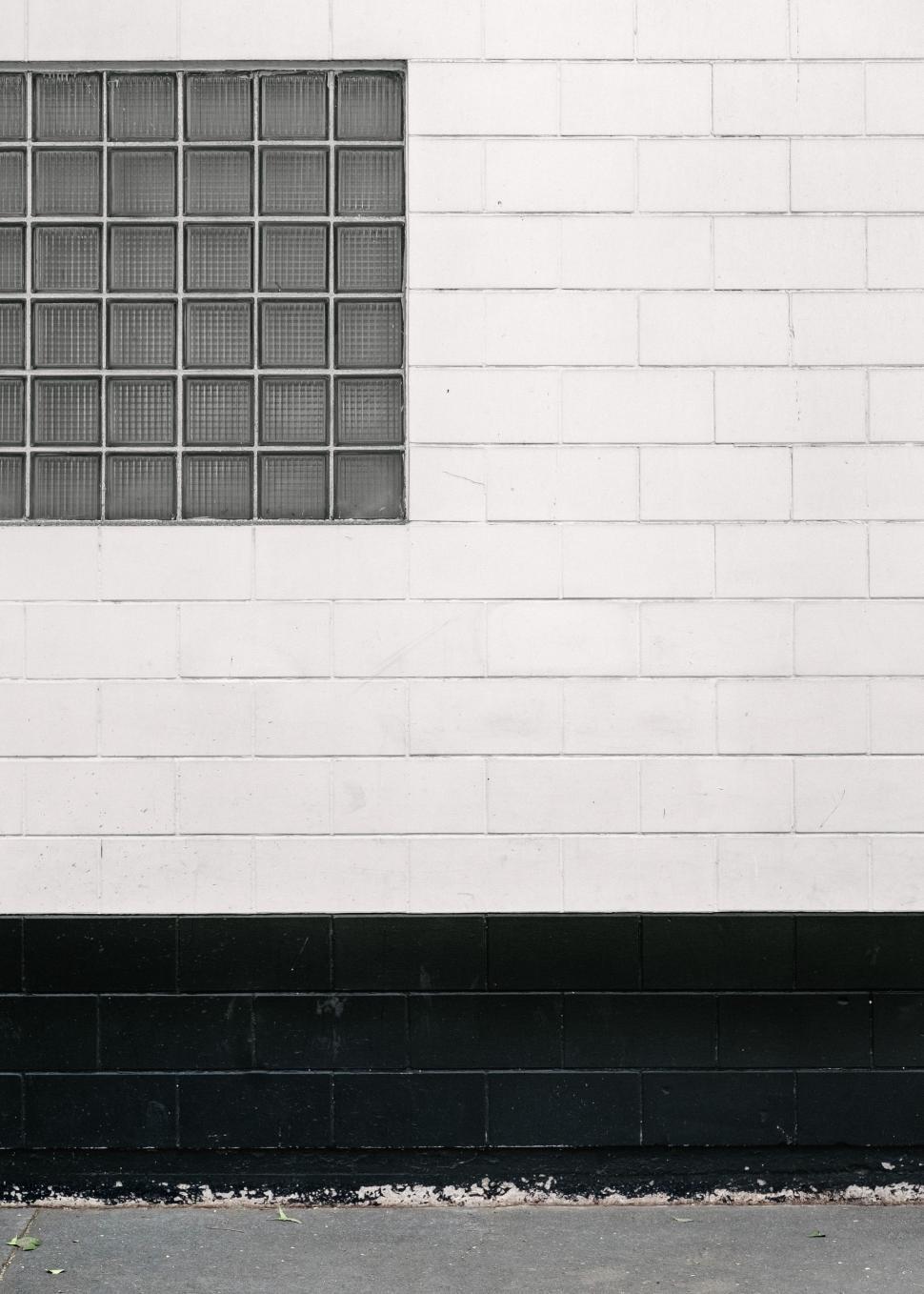 Free Image of Man Riding Skateboard Down Street Next to Building 