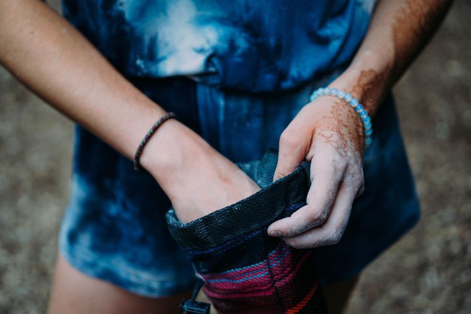 Free Image of Man Wearing Blue Shirt Holding Pair of Gloves 