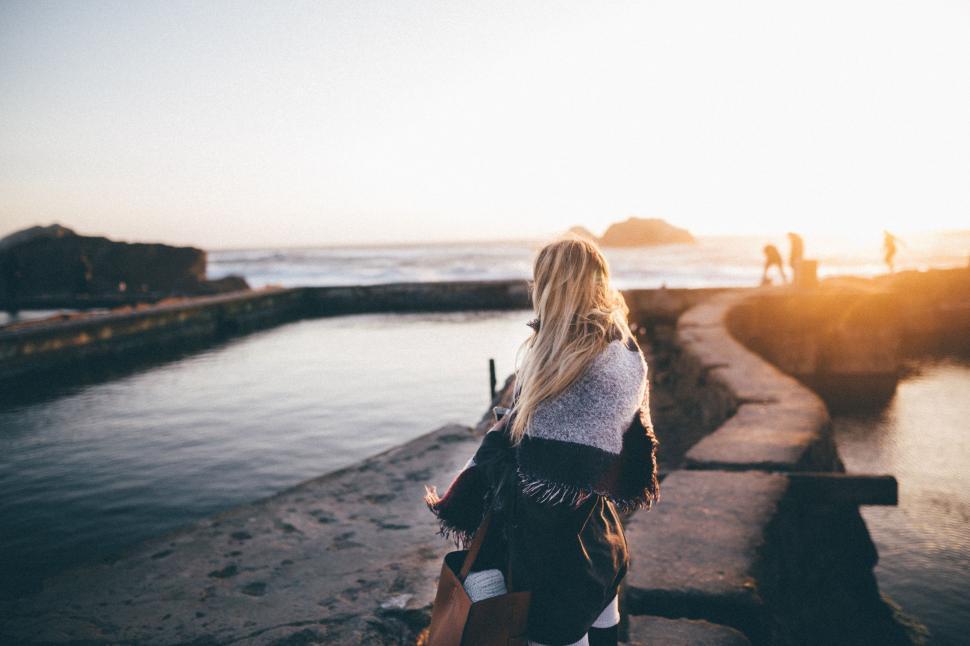 Free Image of Woman Walking Along Beach Next to Ocean 