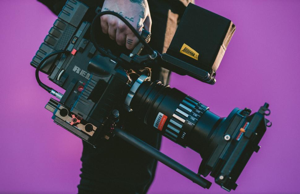 Free Image of Man Holding Camera With Purple Background 