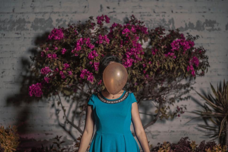 Free Image of Doll in a Blue Dress Standing by Tree 