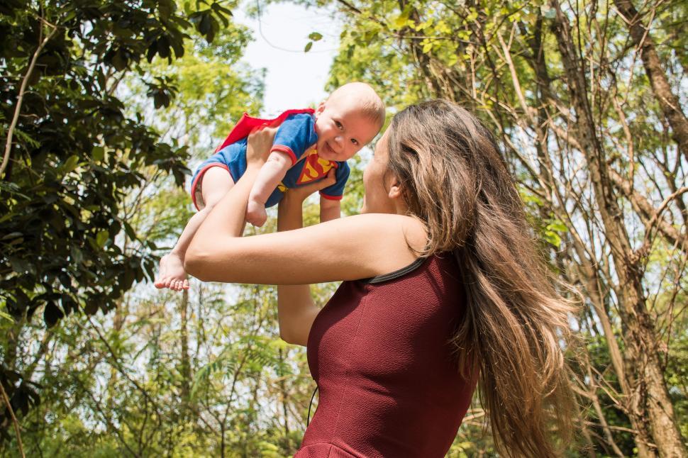 Free Image of Woman Holding Baby Up in the Air 