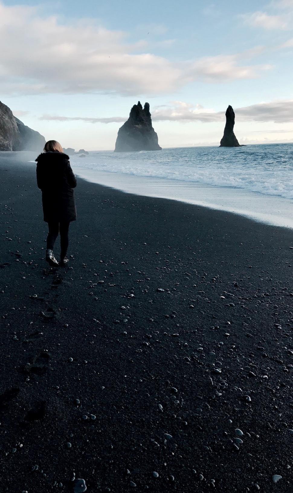 Free Image of Person Walking on Beach Next to Ocean 