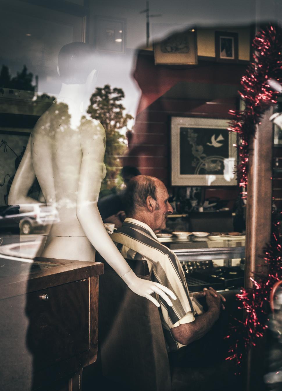 Free Image of Man Sitting in Chair Next to Mannequin 