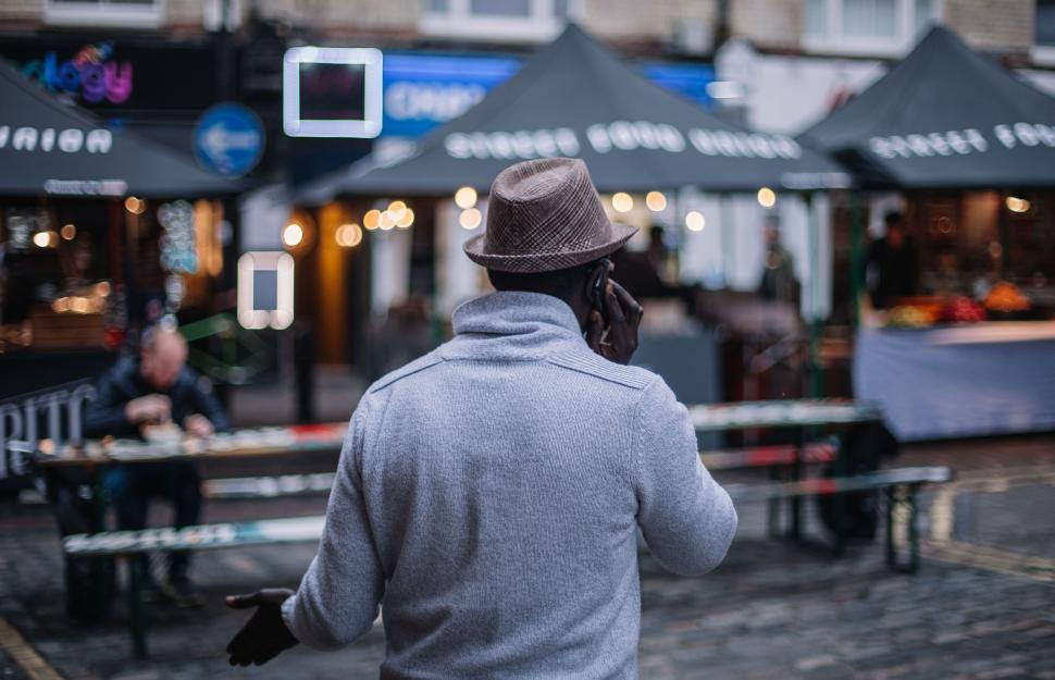 Free Image of Man in a Hat Walking Down the Street 