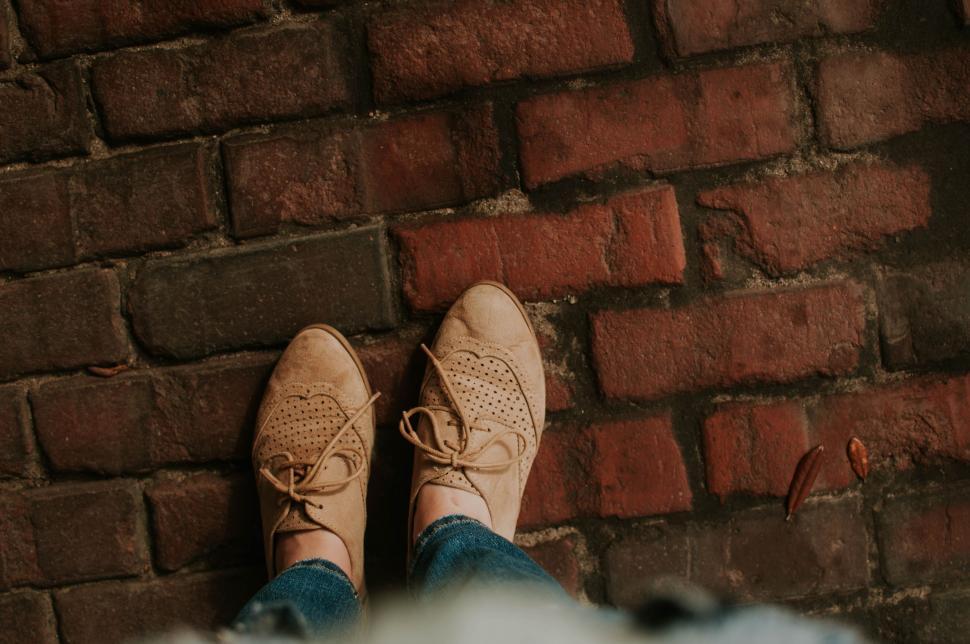 Free Image of Person Standing in Front of Brick Wall 